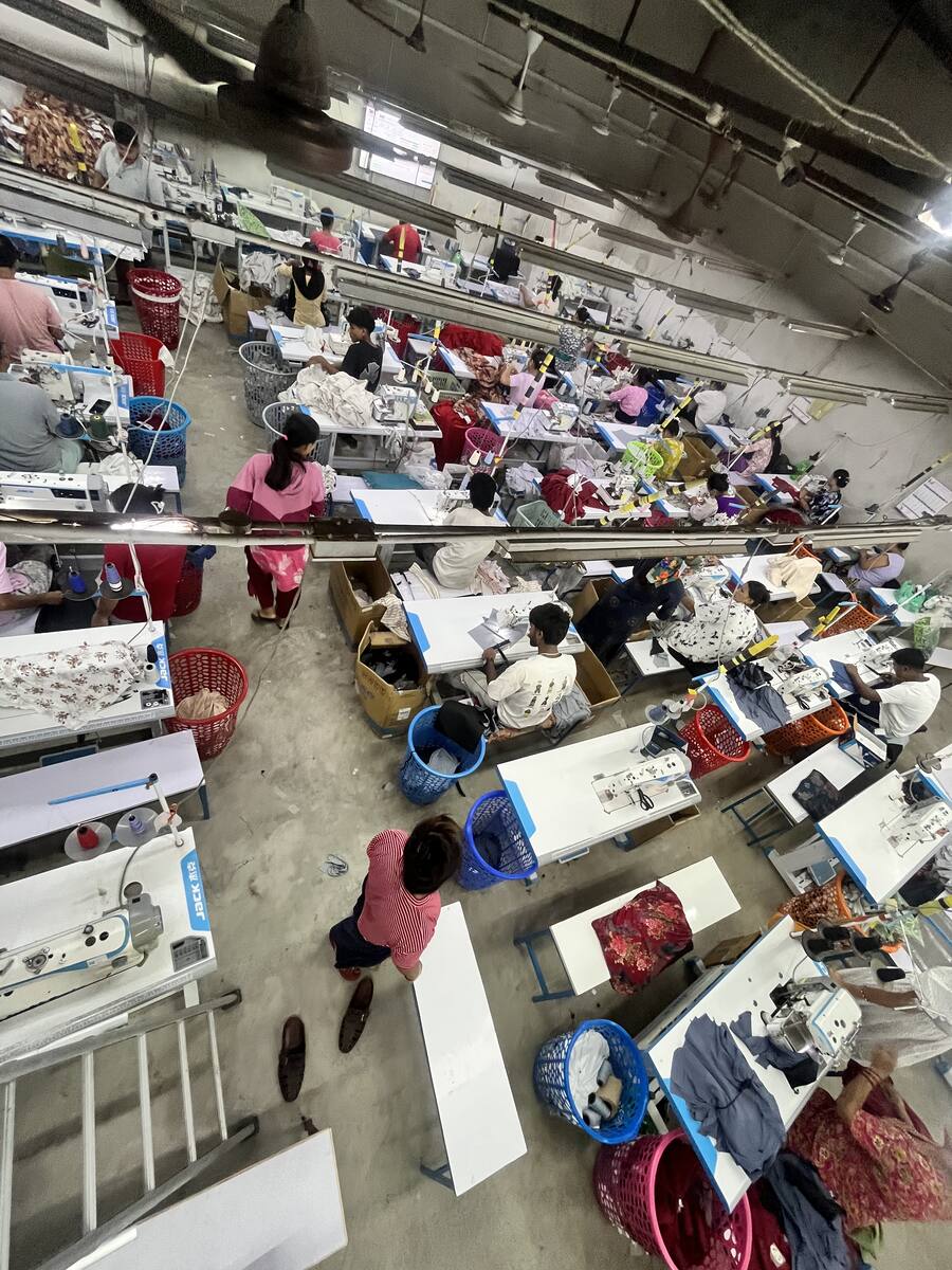 The Trishakti Apparel sewing floor in Gaindakot, Nepal, seen from above — rows of industrial machines with operators at work
