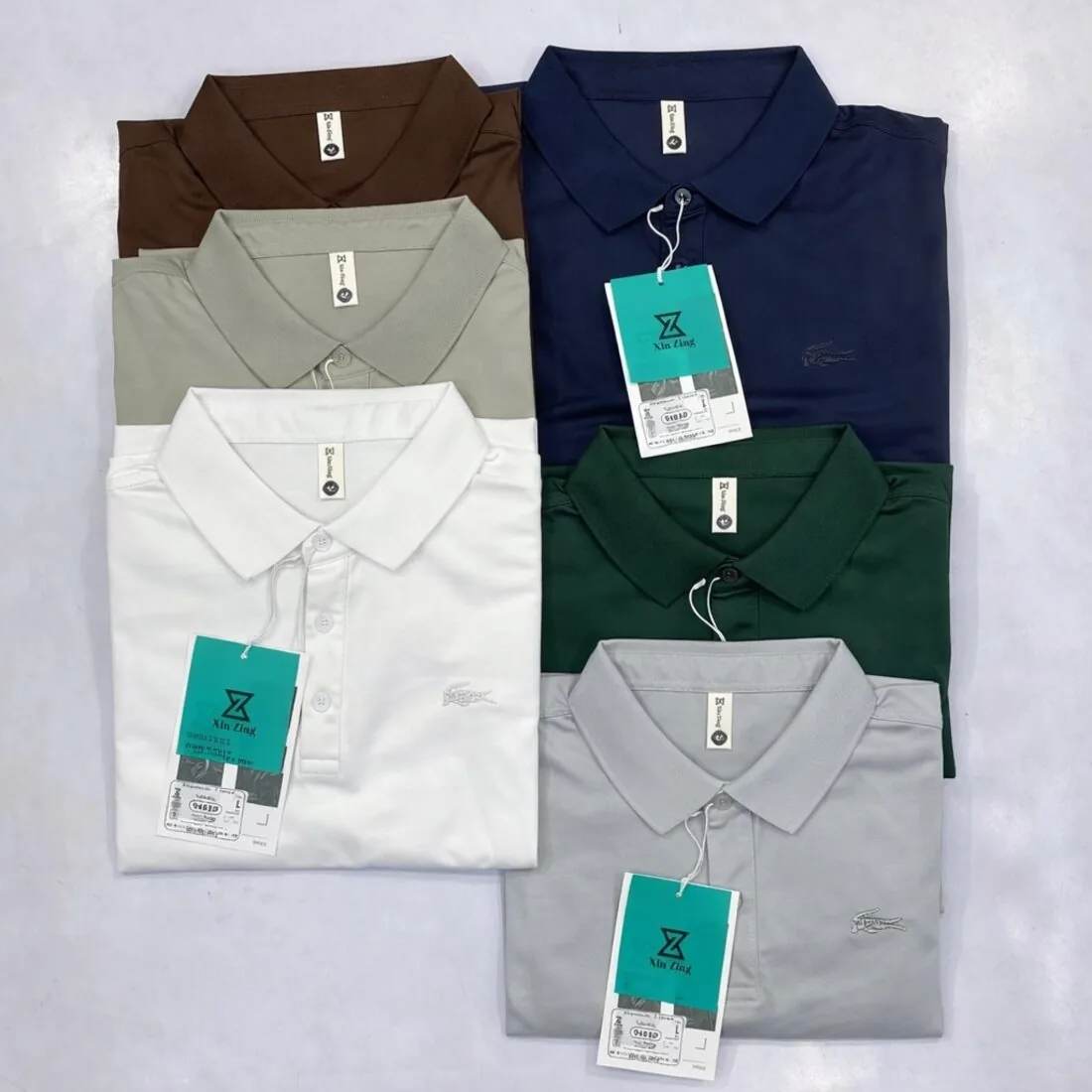 Pique polo shirts in multiple colours, laid flat with hangtags