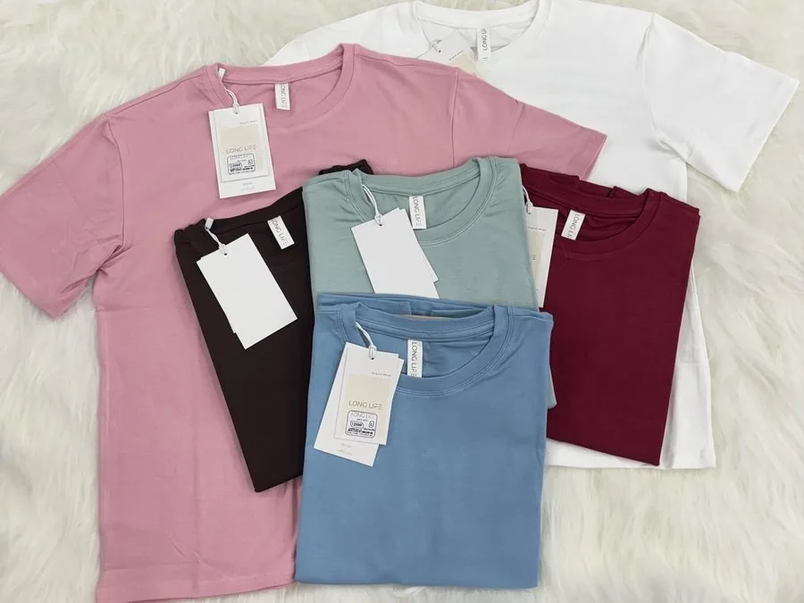 Folded private-label crew-neck t-shirts in multiple colours with hangtags